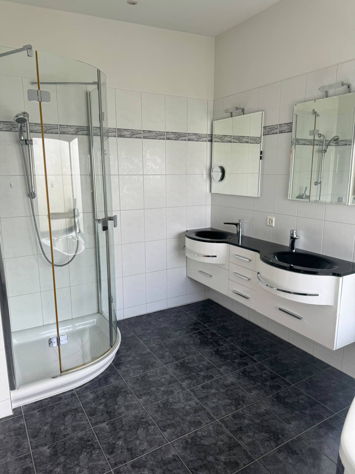 Badezimmer mit Doppellavabo und Runddusche