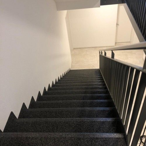 Frisch gereinigtes Treppenhaus mit dunklen Granitstufen