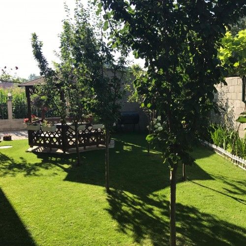 Gartenanlage mit Pavillon, Bäumen und gepflegtem Rasen