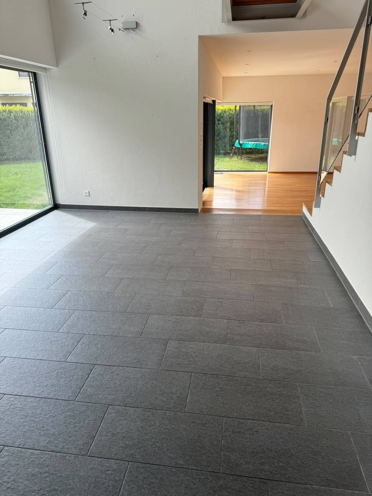 Wohnraum mit gereinigtem Plattenboden und Gartenausgang