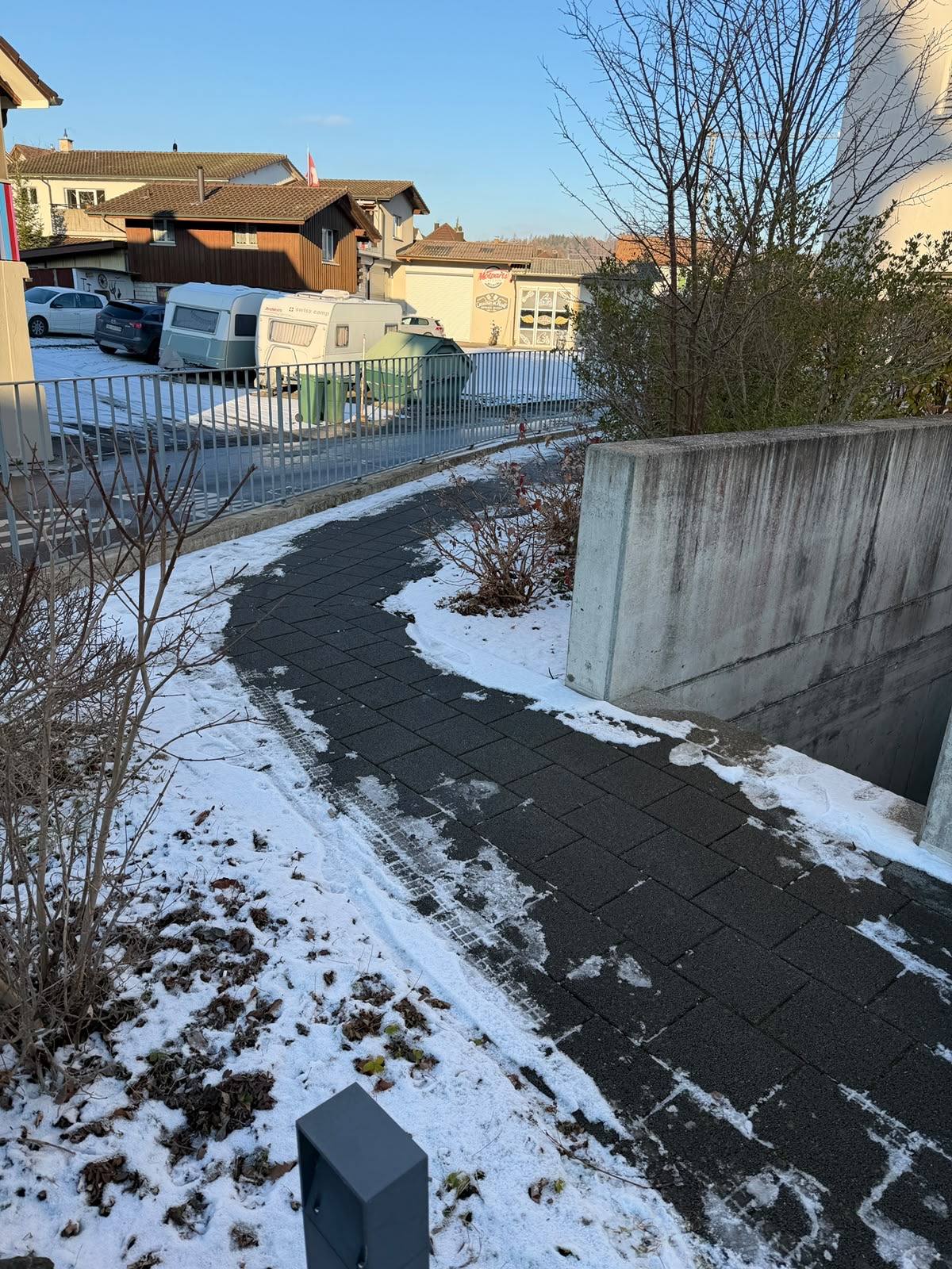 Geräumter Gehweg entlang einer Liegenschaft